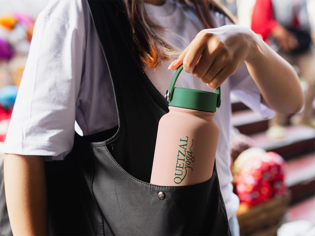 lifestyle photo of an om quetzal water bottle with the logo