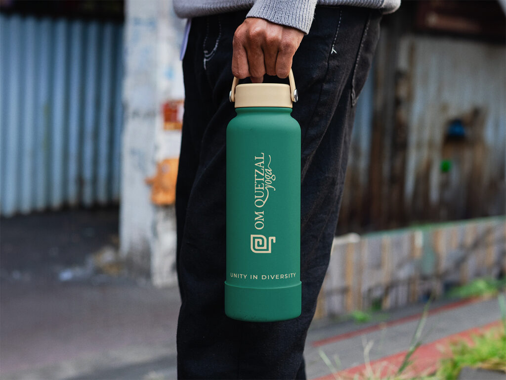 lifestyle photo of an om quetzal water bottle with the logo